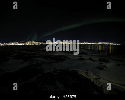 aurora borealis at night in tromsoe city with full moon