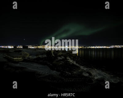 aurora borealis at night in tromsoe city with full moon