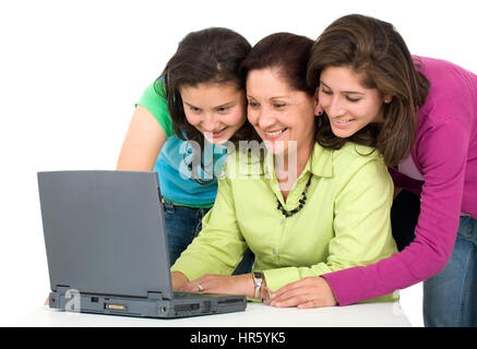 happy family formed by the mother and two daughters on a laptop computer - isolated over a white background Stock Photo