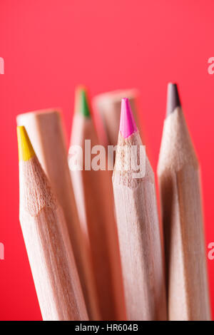 Macro view of crayons. Colored Pencils. Colored pencils on the red background. Stock Photo