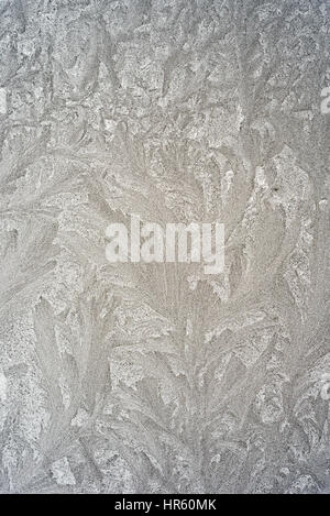 Frozen ice pattern on a glass window during the cold winter weather Stock Photo