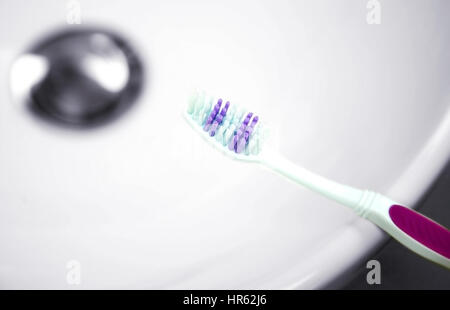 purple toothbrush  on a sink Stock Photo