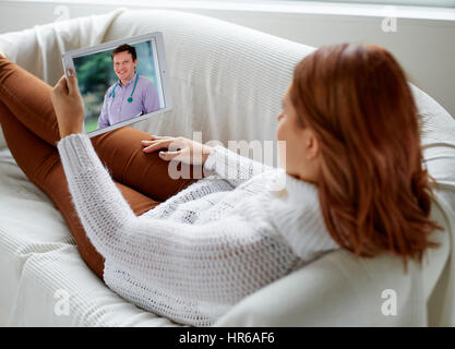 Woman using iPad to talk to her Doctor online Stock Photo
