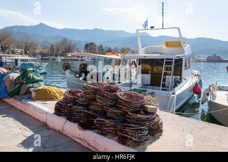 White fishing boats and pile of fishing nets at the harbor of Limenas, Thassos island, Greece Stock Photo