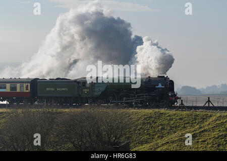 Puffing clouds of smoke, Locomotive, No. 60163 Tornado, a brand new Peppercorn A1 Pacific, travels across the Ribblehead Viaduct on a grey winter day. Stock Photo