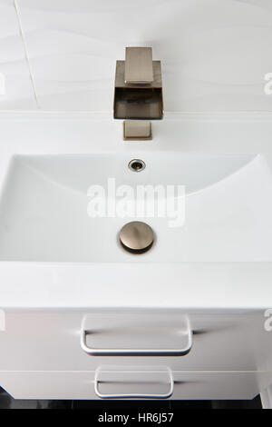 White modern design bathroom vanity with white marble sink and brushed nickel  waterfall faucet Stock Photo