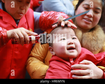 Hefei, China. 27th Feb, 2017. A barber cuts the hair of a child in Hefei, east China's Anhui Province. It's Dragon Heads-raising Day on February 27th, 2017. Many Chinese people will hit the barbers' chair in search of good luck and prosperity on this day. Credit: SIPA Asia/ZUMA Wire/Alamy Live News Stock Photo