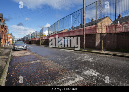 A peace wall several meters high in a pro-Irish part of Belfast, Northern Ireland, 27 February 2017. Mighty walls and metal fences snake through Belfast, some over twelve meters high and crowned by barbed wire. They separate residential areas from each other, in a straight line or in a zigzag course. The Catholics live on one side, the Protestants on the other. Photo: Mariusz Smiejek/dpa Stock Photo