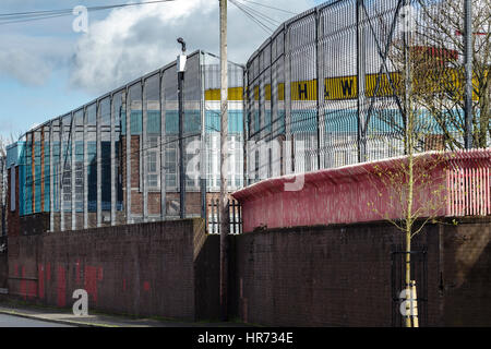 A peace wall several meters high in a pro-Irish part of Belfast, Northern Ireland, 27 February 2017. Mighty walls and metal fences snake through Belfast, some over twelve meters high and crowned by barbed wire. They separate residential areas from each other, in a straight line or in a zigzag course. The Catholics live on one side, the Protestants on the other. Photo: Mariusz Smiejek/dpa Stock Photo