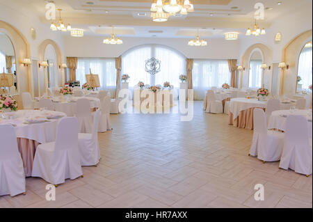 Luxury decorated marriage hall with guests and newlyweds tables Stock Photo