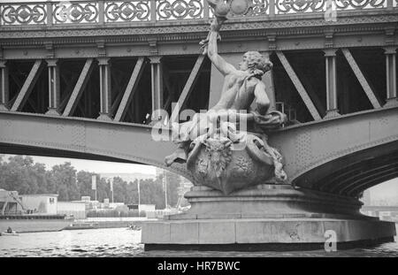 The Mirabeau Bridge over the Seine River feature bronze sculptures on the piles. This figure on the right bank is The Navigation. Stock Photo