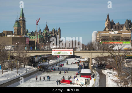 People ice skating on the frozen Rideau canal, Ottawa on a sunny day, during the annual Winterlude, bal de Neige winter festival. Stock Photo