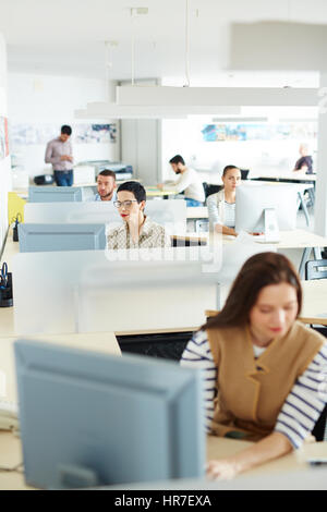 Separate workplace cubicles with different people sitting at them in open space of modern office Stock Photo