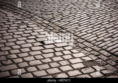 The cobbled pavement outside the Tower of London, polished to a shine by millions of tourists, glints in the early morning sunshine. Stock Photo