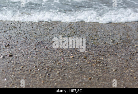 Pebbles on the beach with the tide going out. Stock Photo