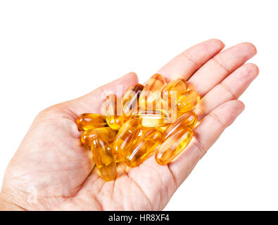 Fish oil pills in female hand isolated on white background, Saved clipping path. Stock Photo