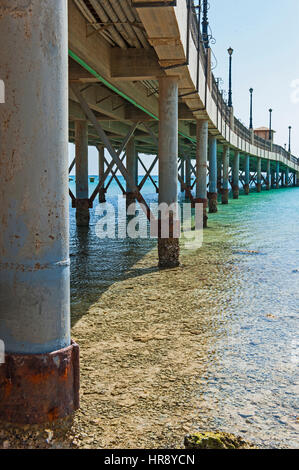Metal supports of large pier in tropical sea on resort beach Stock Photo
