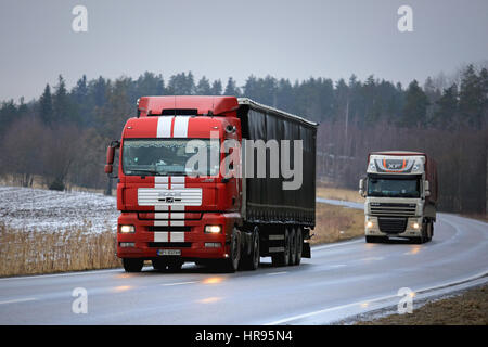 SALO, FINLAND - FEBRUARY 17, 2017: MAN and DAF XF semi trailer trucks on the road on a cloudy day in winter. Stock Photo