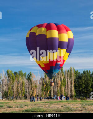 Hot Air Balloon lifting off from a field Stock Photo