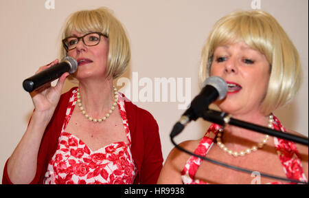 Female vocalists of local band - Out of the Shadows - performing popular songs from the 1960s at a community event organised by the local town council Stock Photo