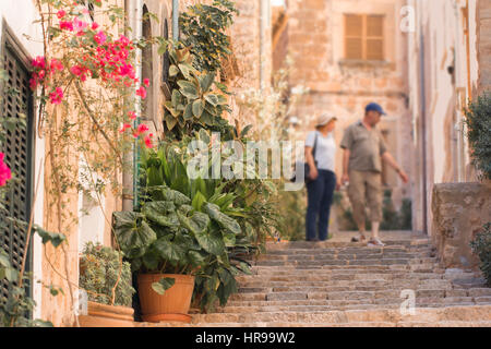 tourists walking on typical mediterranean street in small town Stock Photo