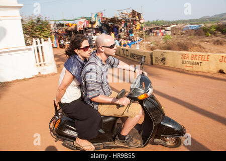 Tourist,tourists,on,a,scooter,without,no,helmets,helmet,at,Anjuna,Market,beach,Goa,India,Indian,Asia,Asian. Stock Photo