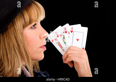 Fashion woman showing a royal flush - isolated over a black background Stock Photo