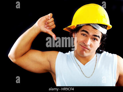 male builder or constructor giving the thumbs down over a black background Stock Photo