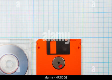 vintage background - computer floppy disks and mini-CD on the blueprint paper, toned Stock Photo