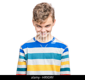 Teen boy making silly grimace - expressing cunning face. Upset child isolated on white background. Emotional portrait of caucasian teenager looking at Stock Photo