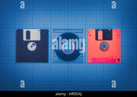 vintage background - computer floppy disks and mini-CD on the blueprint paper, toned Stock Photo