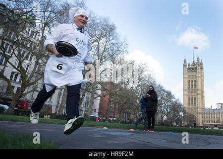 MP for Ealing North Steve Pound takes part in the annual Rehab Parliamentary Pancake Race in which MPs, Lords and members of the media race each other on pancake day to raise money for the charity Rehab, in Victoria Tower Gardens, London. Stock Photo