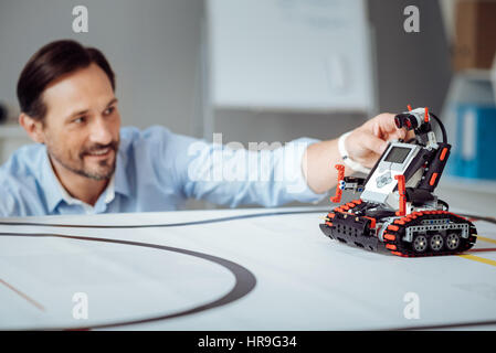 Positive professional engineer testing the robot Stock Photo