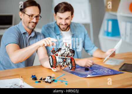 Positive engineers examining the robot Stock Photo