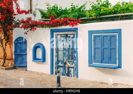 Facade of a very small white house with blue windows in Halkidiki, Greece Stock Photo