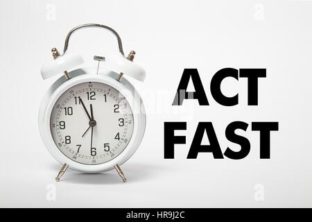 White old clock with text  ACT FAST Stock Photo