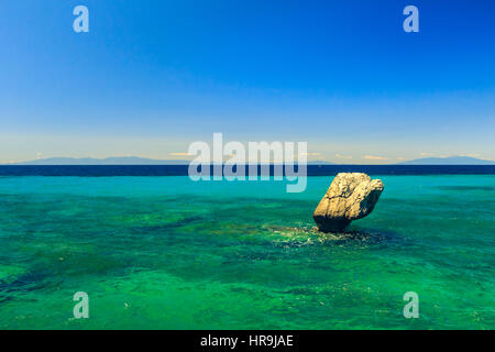 The rocky coast overlooking the turquoise blue sea in the warm summer day. Greece. Halkidiki Stock Photo