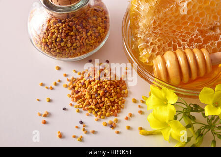 Containers with honey, honeycomb and pollen bee. Decoration with flowers and pollen grains. Top view. Horizontal composition Stock Photo
