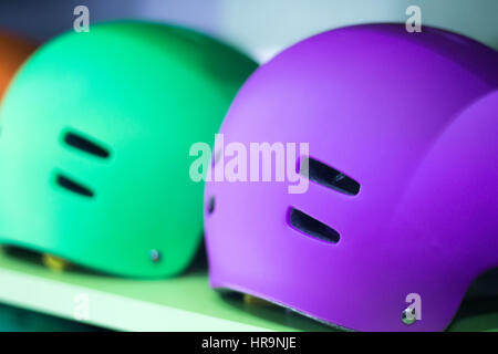 Inline and quad roller skates helmets head protection in retail skate shop display on sale. Stock Photo