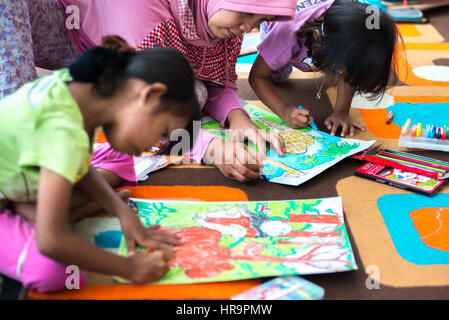 Female children drawing with mother. Stock Photo