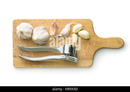 Garlic and garlic press on cutting board isolated on white background. Stock Photo