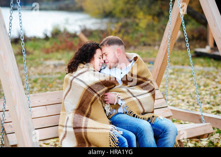 Amorous couple on romantic date on swings outdoor ,autumn Stock Photo