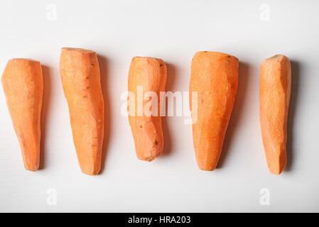 peeled carrots, five pieces lying on the whiteboardpeeled carrots, five pieces lying on the white board, white background Stock Photo
