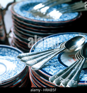 Silver teaspoons engraved with family crest on blue and white plates