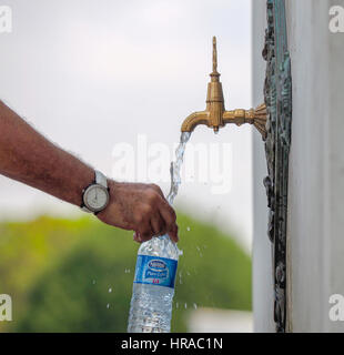 FILLING PLASTIC WATER BOTTLE FROM TAP IN SULTANAHMET SQUARE GARDEN ISTANBUL TURKEY Stock Photo