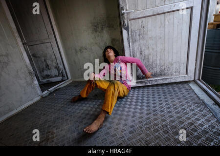 A mentally handicapped refugee girl age 9, chained to a toilet by the ankle in Zakho IDP camp near Dohuk, Kurdistan, Iraq. Stock Photo