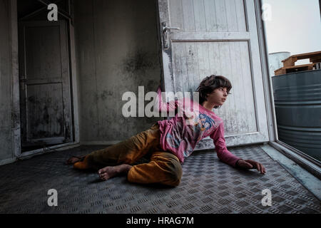 A mentally handicapped refugee girl age 9, chained to a toilet by the ankle in Zakho IDP camp near Dohuk, Kurdistan, Iraq. Stock Photo