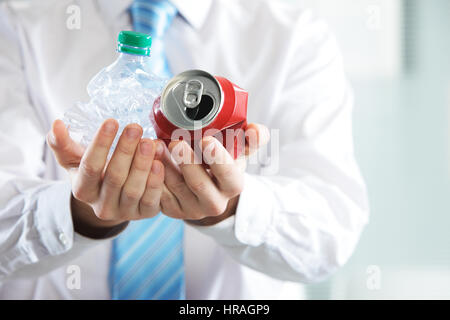 Businessman holding a crashed bottle and drink can, Recycle concept Stock Photo