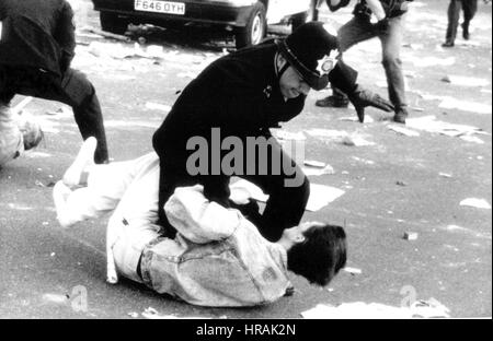A police officer grapples with a protestor during the Poll Tax Riots in Trafalgar Square in London, England on March 31, 1990. The unpopular tax was introduced by the Conservative government led by Prime Minister Margaret Thatcher. Stock Photo