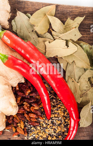 Seasoning concept - Assortment of fresh and dry spices on wooden background, chili, bay leaves, ginger, coriander, seeds Stock Photo